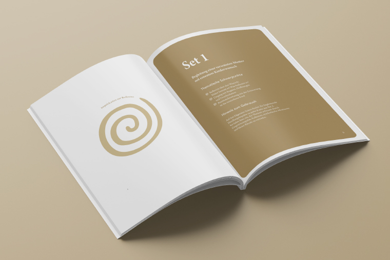 aufgeschlagene goldfarbene broschüre auf beigem Hintergund